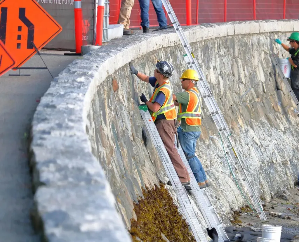 crew inspecting and repairing a seawall
